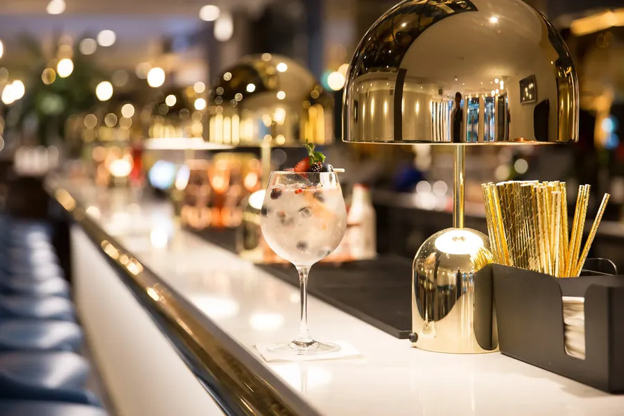 Softly lit London cocktail bar with gold lamps