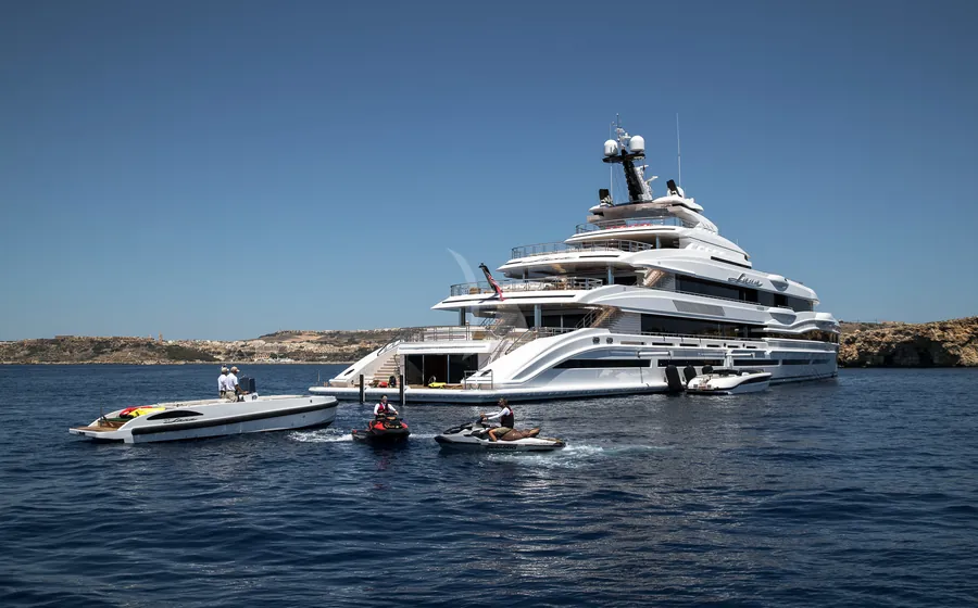 Superyacht at anchor with tenders and jet skis